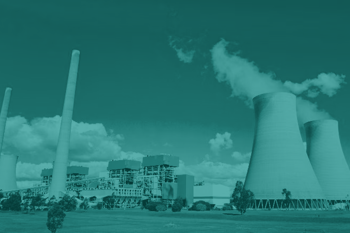Power plant with smokestacks emitting steam against a blue sky