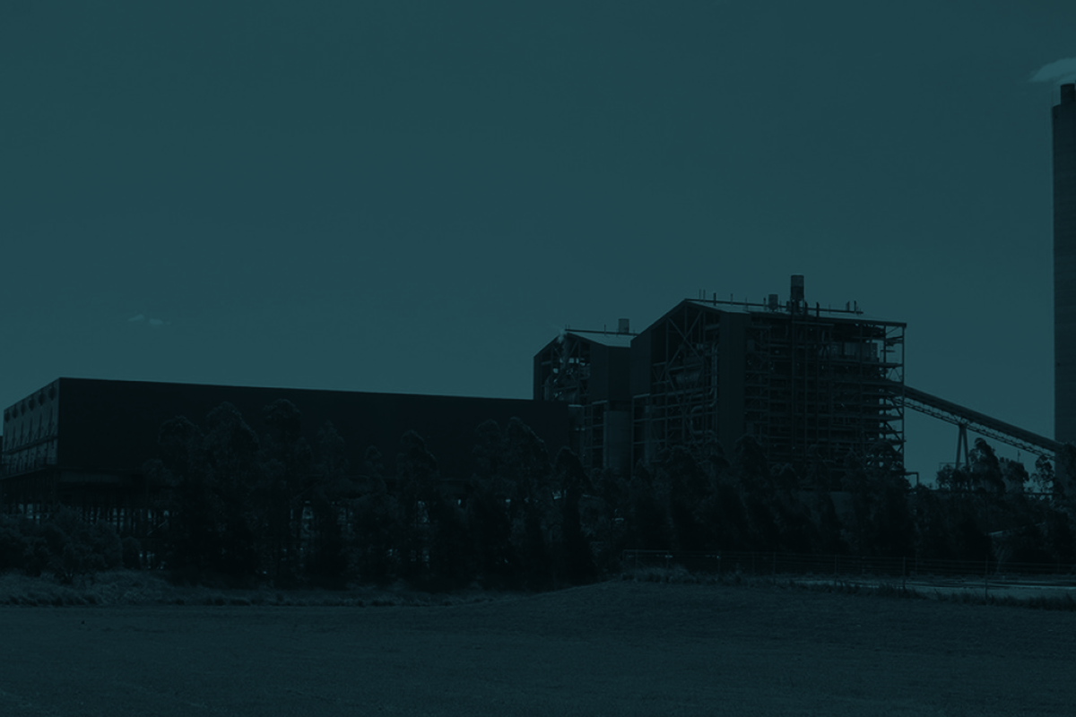 Industrial area with large buildings and a truck at night.
