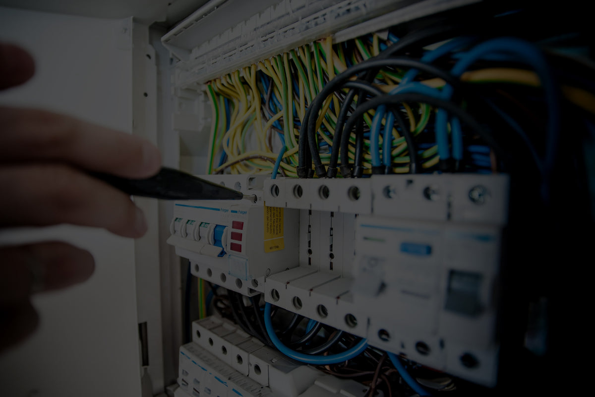 Person working on electrical panel with wires and tools