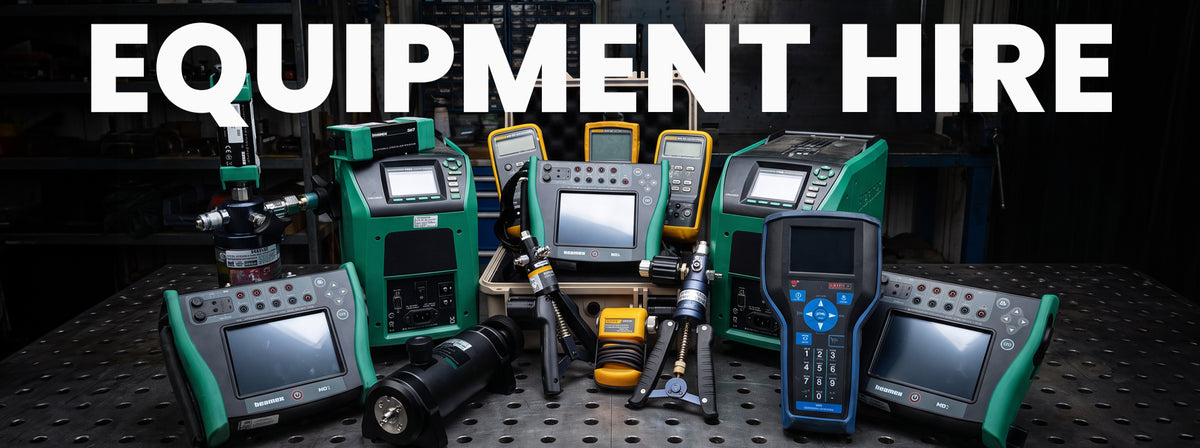 A collection of industrial testing and measurement equipment arranged on a dark workbench, with large white text reading 'EQUIPMENT HIRE' across the top. The devices are mostly green and black with some yellow and blue accents, and several have attached screens and probes.